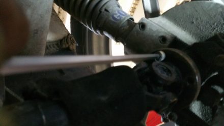 Carefully loosening the drive shaft screws